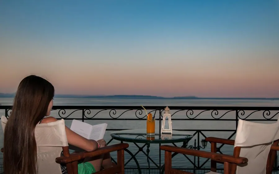 Διάβασμα στο μπαλκόνι πάνω από τη θάλασσα